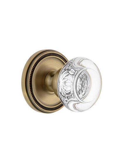 Grandeur Soleil Rosette Door Set with Bordeaux Crystal-Glass Knobs in Antique Brass.